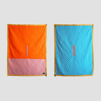 Blanket silhouette showing the fronf of the S.R. Anywear Blanket with Orange and Pink on the left and sky blue on the  right