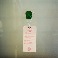 Fern Green S.R. Anywhere Hook holding a Scout Regalia hang tag on  frosted glass