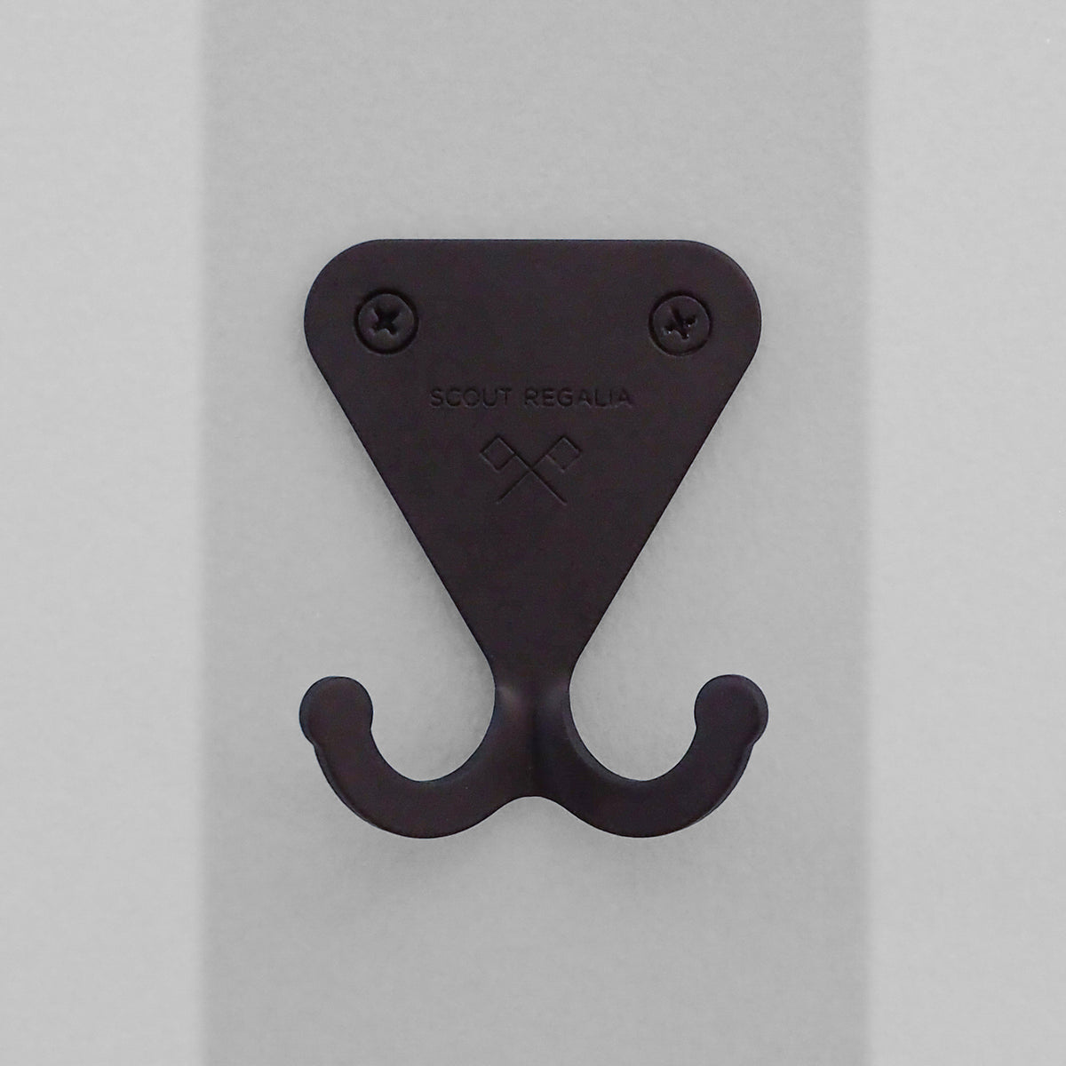Matte Black S.R. Wall Hook on a light grey striped background.
