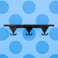Navy Grey S.R. Wall Rack on a light blue polka-dotted background