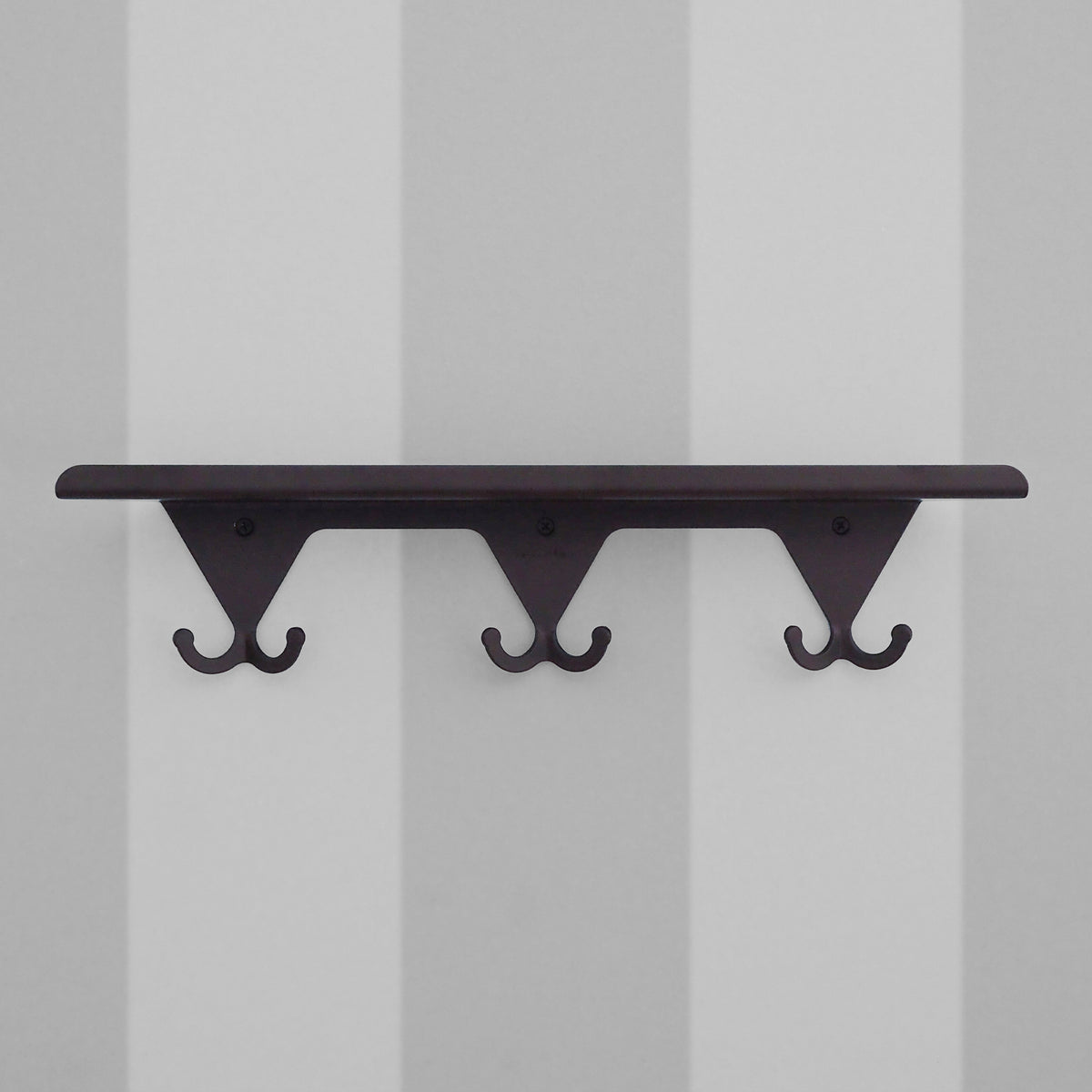 Matte Black S.R. Wall Rack on a light grey striped background.