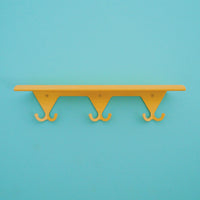 Citrus Yellow S.R. Wall Rack on a turquoise background