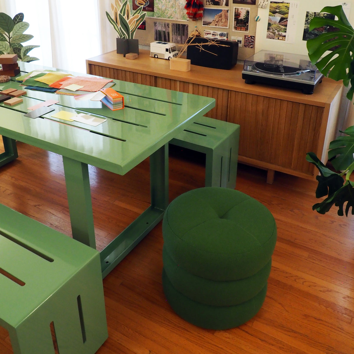 A pale green S.R. All Aluminum Table Set next to a fern Green S.R. Pouf, in front of the S.R. Lodge credenza.