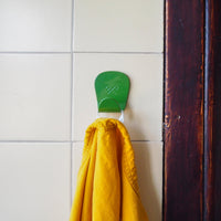 S.R. Anywhere Hook in Fern Green holding an Orange jacket on yellow tile.