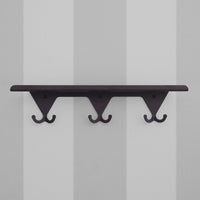 Matte Black S.R. Wall Rack on a light grey striped background.